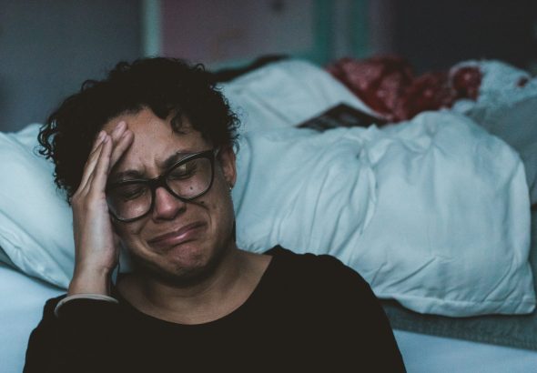 person crying beside bed